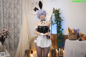 A woman in a bunny costume is sitting on a chair.