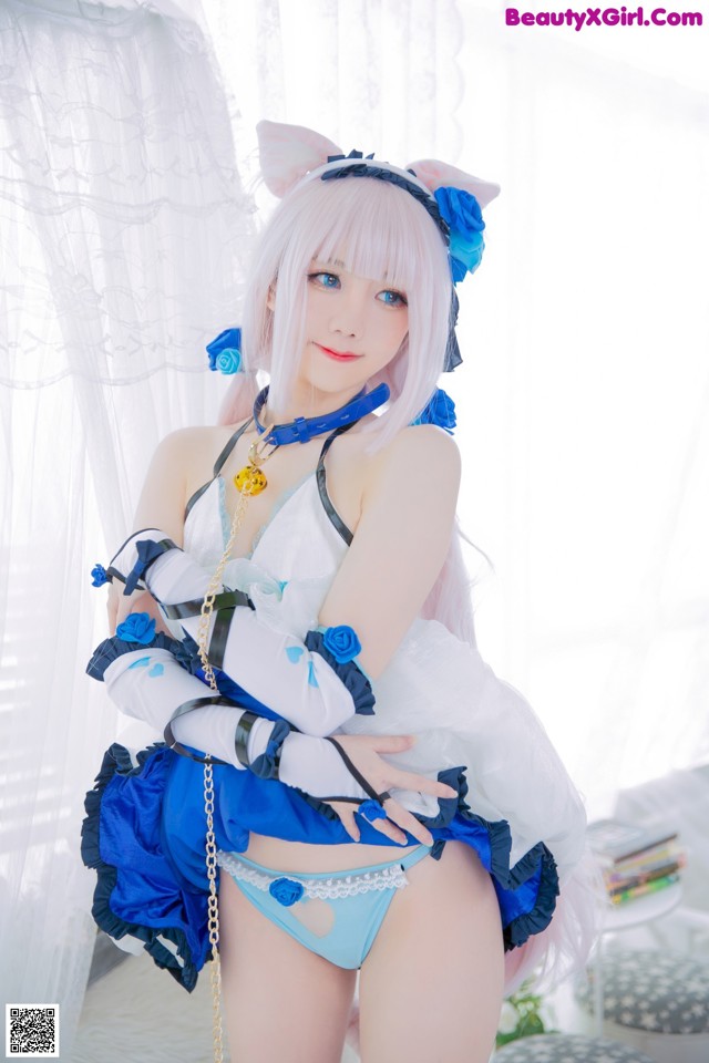 A woman in a blue and white outfit posing for a picture.