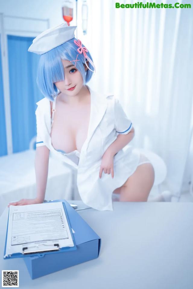 A woman in a white nurse outfit sitting at a table.