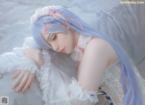 A woman with long blue hair wearing a white corset.