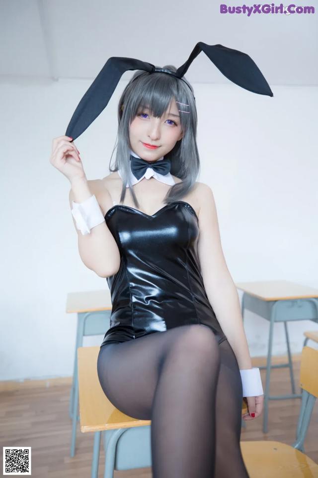 A woman in a bunny costume sitting on a chair.