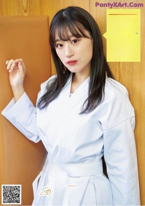 A woman in a white kimono is posing for a picture.