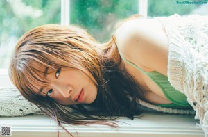 A woman laying on the floor with her head on her hands.