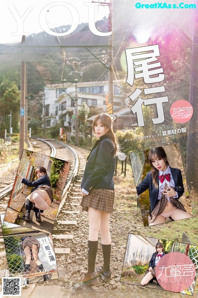 A woman in a school uniform is posing on a train track.