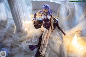 A woman with purple hair sitting on a white couch.