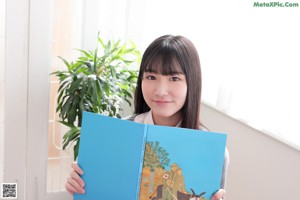 A young woman in a school uniform posing for a picture.