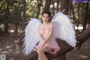 A woman dressed as an angel in a pink dress.