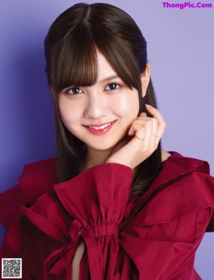 A woman in a red blouse posing for a picture.