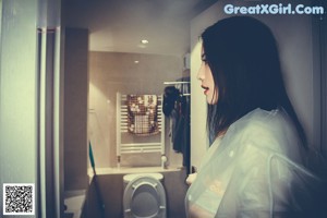 A woman in a raincoat holding a shower head.