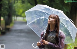 A woman holding an umbrella in the rain. 