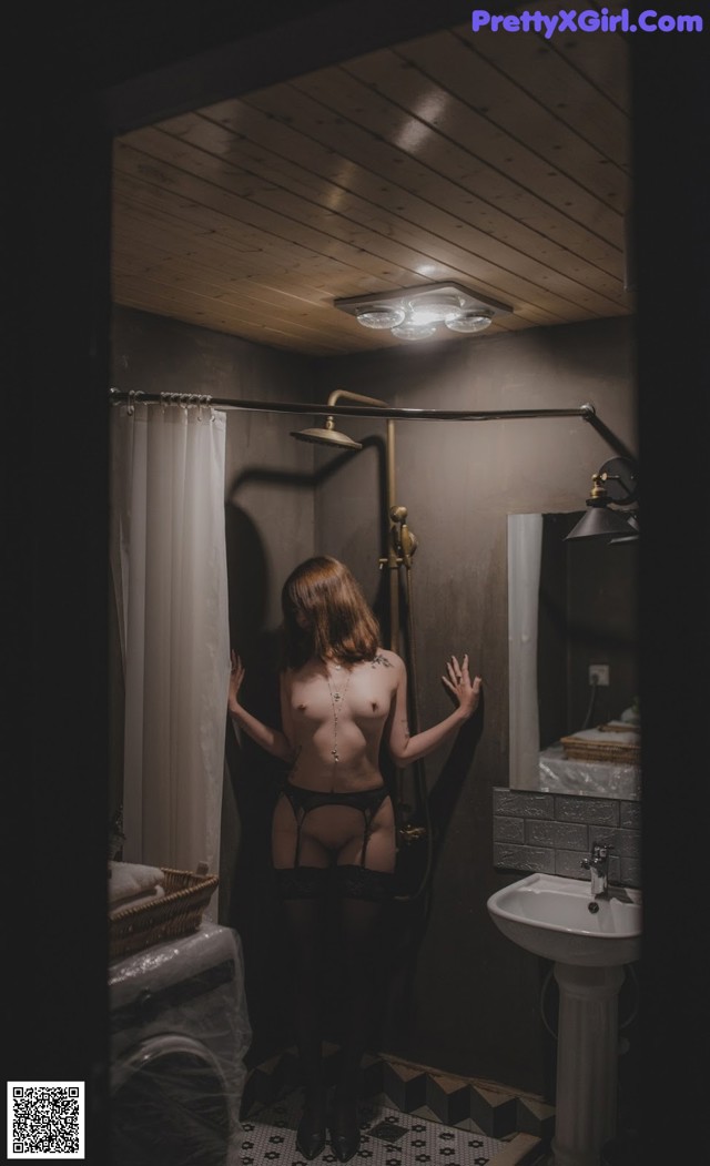 A woman standing in a bathroom next to a sink.