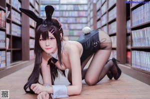 A woman in a bunny costume crouching on the floor.