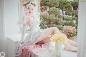 A woman in a maid outfit laying on a bed.