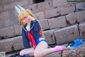 A woman in a bunny costume standing on a beach next to a pair of shoes.