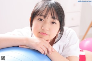 A woman sitting on top of a blue ball.