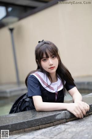 A woman in a school uniform sitting in a pool of water.