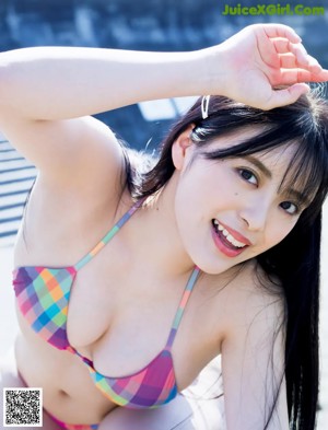 A woman in a pink bikini holding a glass of water.