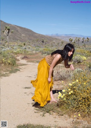 A woman laying on top of a large rock.